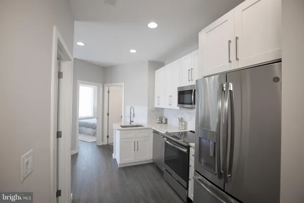 a kitchen with stainless steel appliances a refrigerator sink and cabinets