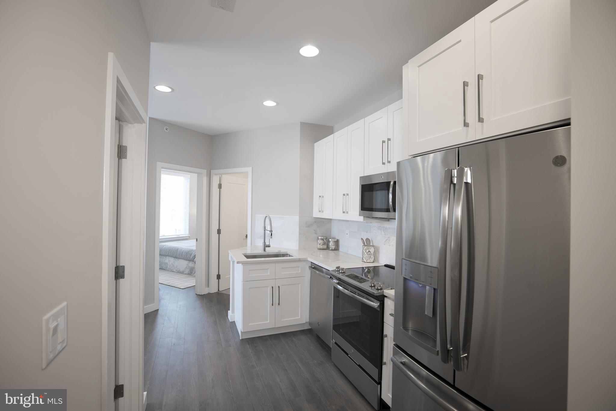1508 Ridge Avenue, Unit 501 Philadelphia, PA 19130 - Photo 5 of 19 a kitchen with stainless steel appliances a refrigerator sink and cabinets