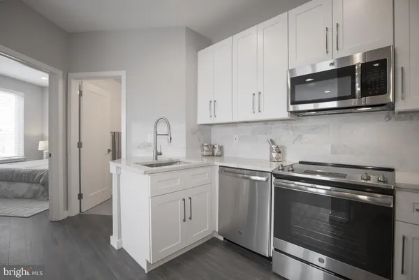 a kitchen with stainless steel appliances granite countertop white cabinets a sink and dishwasher