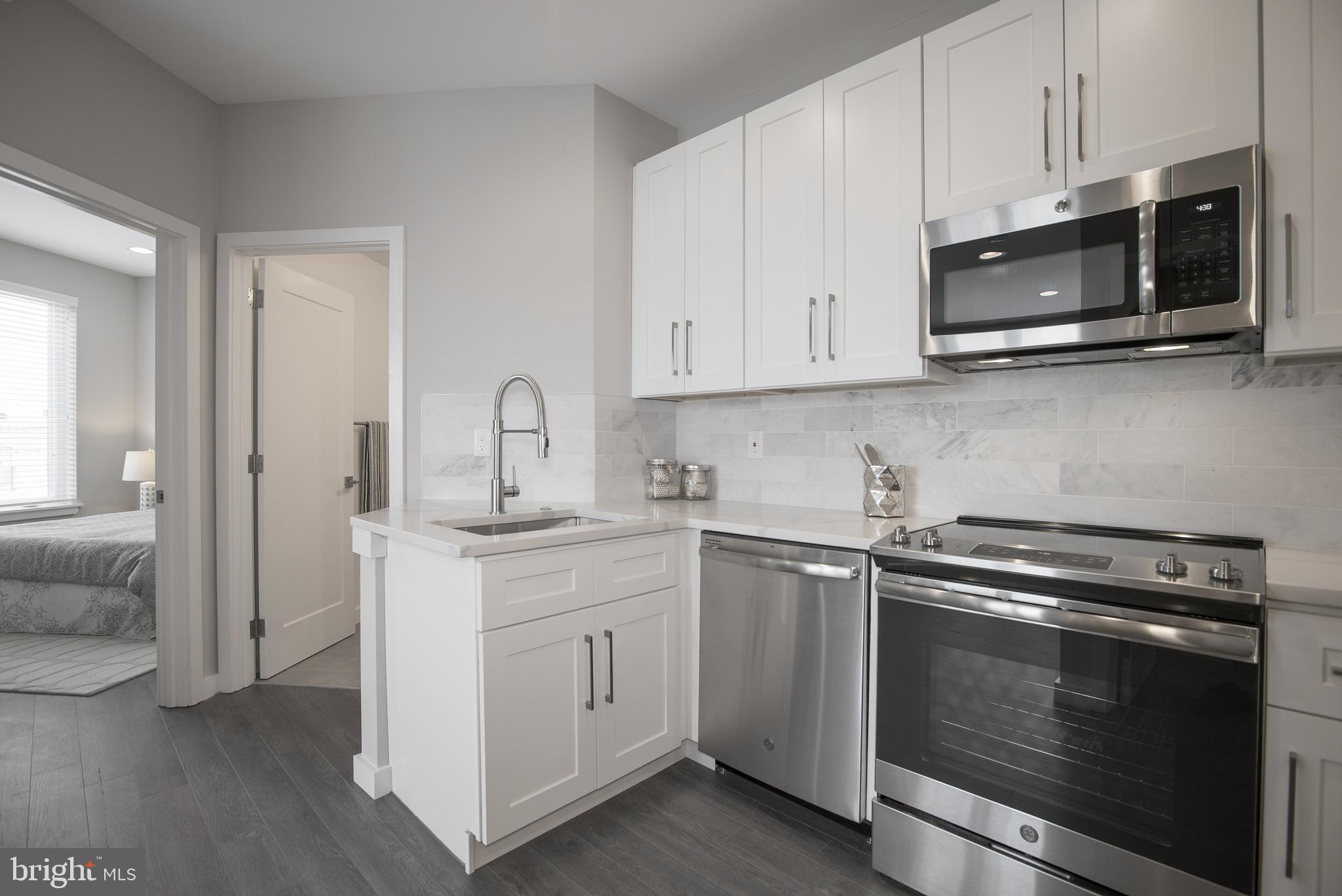 1508 Ridge Avenue, Unit 501 Philadelphia, PA 19130 - Photo 6 of 19 a kitchen with stainless steel appliances granite countertop white cabinets a sink and dishwasher