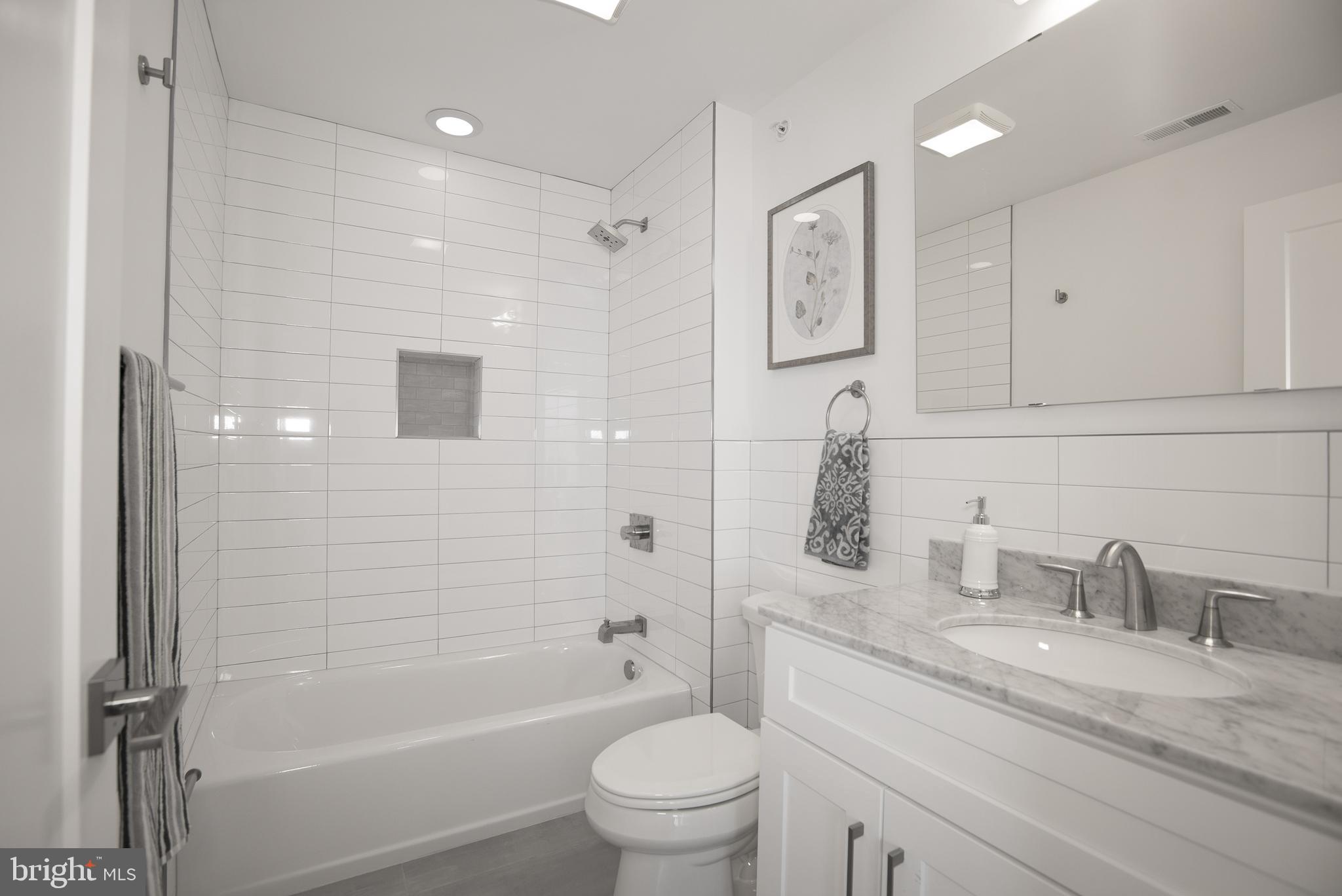 1508 Ridge Avenue, Unit 501 Philadelphia, PA 19130 - Photo 8 of 19 a bathroom with a granite countertop sink a toilet and shower