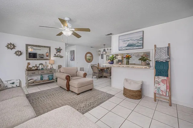 a living room with furniture and a view of kitchen