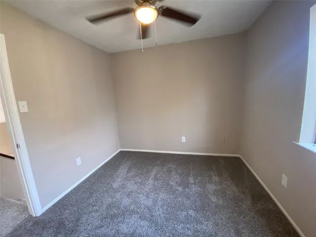 an empty room with closet and a ceiling fan