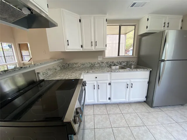 a kitchen with a refrigerator and a stove