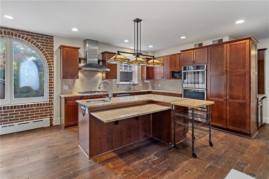 5515 Darlington Road Pittsburgh, PA 15217 - Photo 16 of 50 a kitchen with kitchen island granite countertop wooden cabinets and a stove
