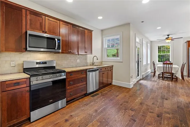 a kitchen with stainless steel appliances granite countertop a stove a sink and a microwave