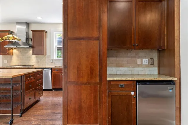 an empty room with wooden floor fireplace and windows