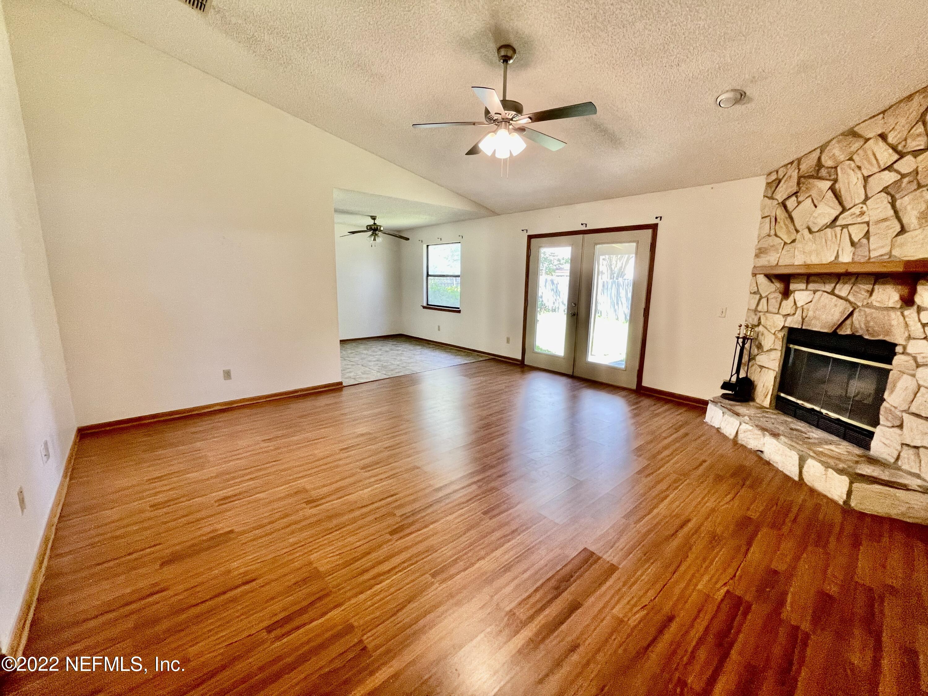 3248 Merganzer Trail Orange Park, FL 32065 - Photo 3 of 17 an empty room with wooden floor fireplace and windows