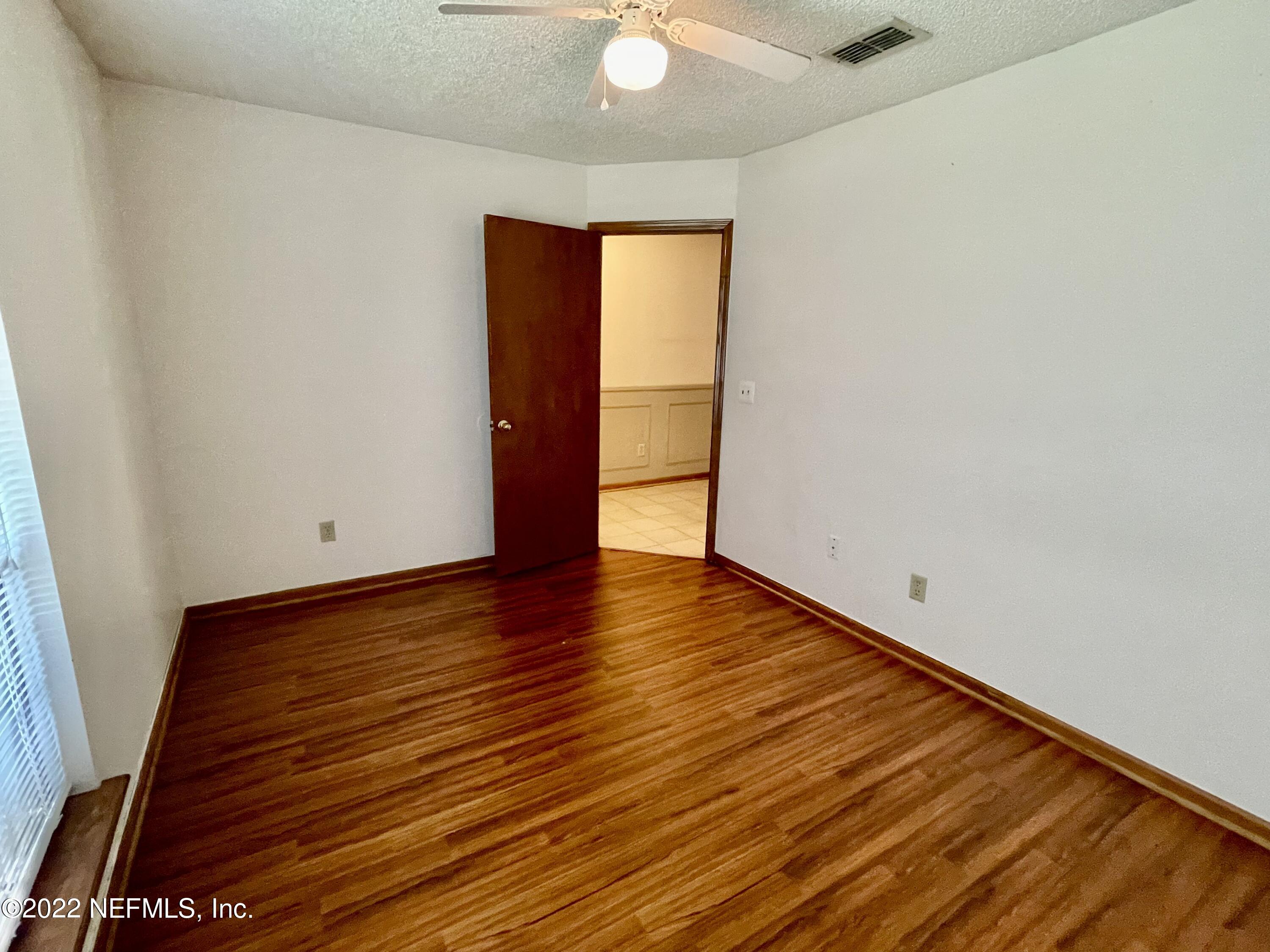 3248 Merganzer Trail Orange Park, FL 32065 - Photo 6 of 17 a view of an empty room with wooden floor and a window