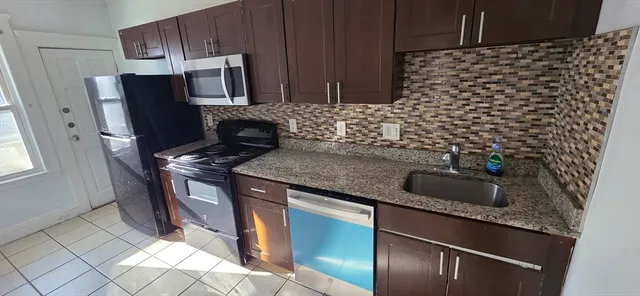 a kitchen with granite countertop a sink and a stove top oven