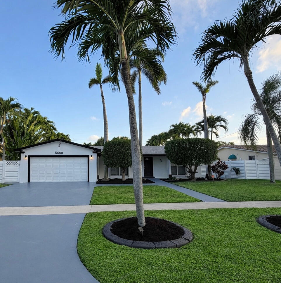5408 Jackson Street Hollywood, FL 33021 - Photo 3 of 42 a front view of a house with garden and palm tree