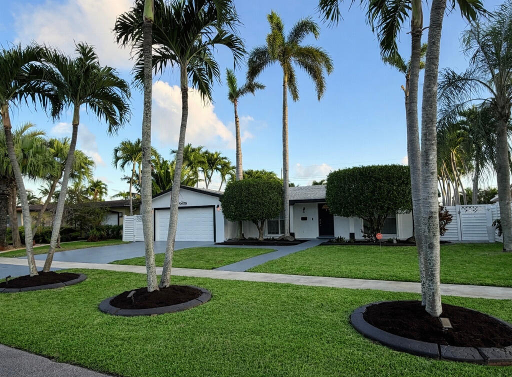 5408 Jackson Street Hollywood, FL 33021 - Photo 4 of 42 a front view of a house with garden and trees