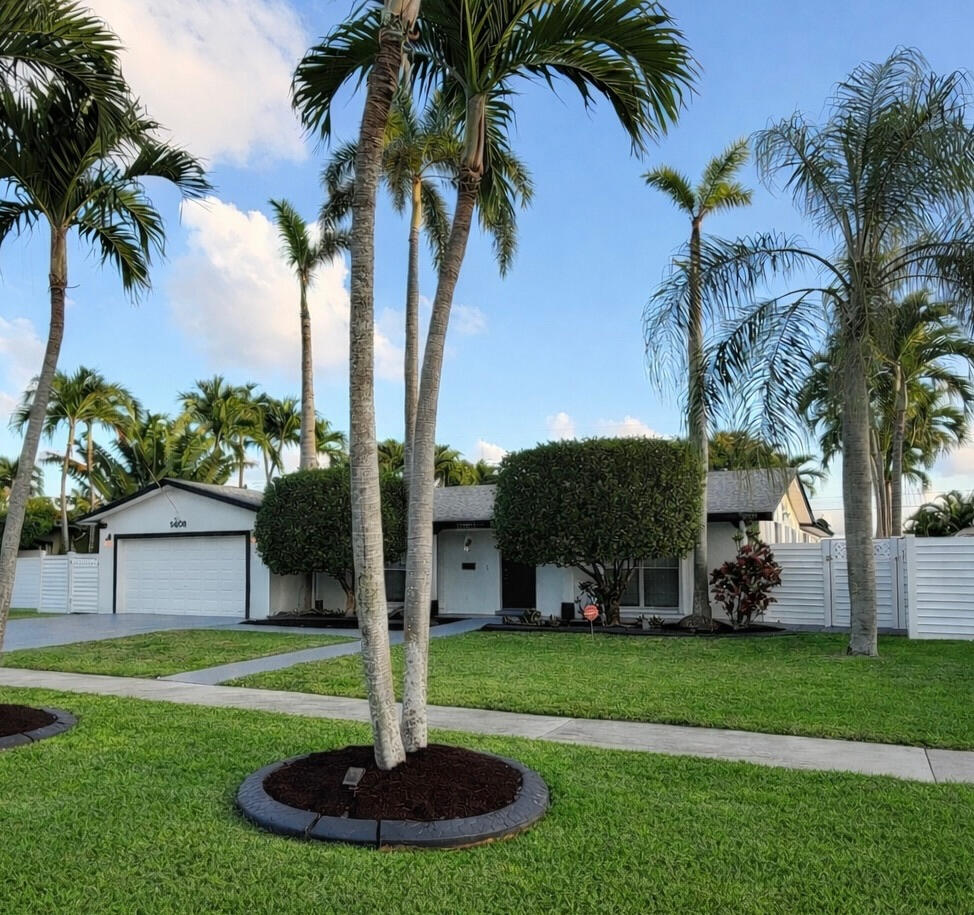 5408 Jackson Street Hollywood, FL 33021 - Photo 5 of 42 a front view of a house with garden and trees
