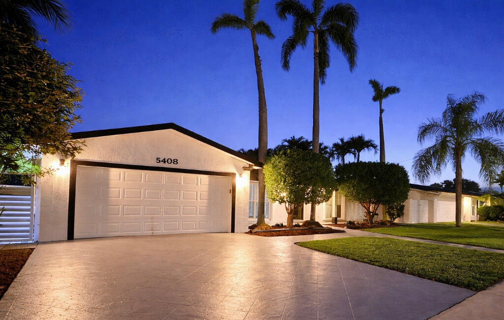 5408 Jackson Street Hollywood, FL 33021 - Photo 9 of 42 a view of a house with a yard and palm trees