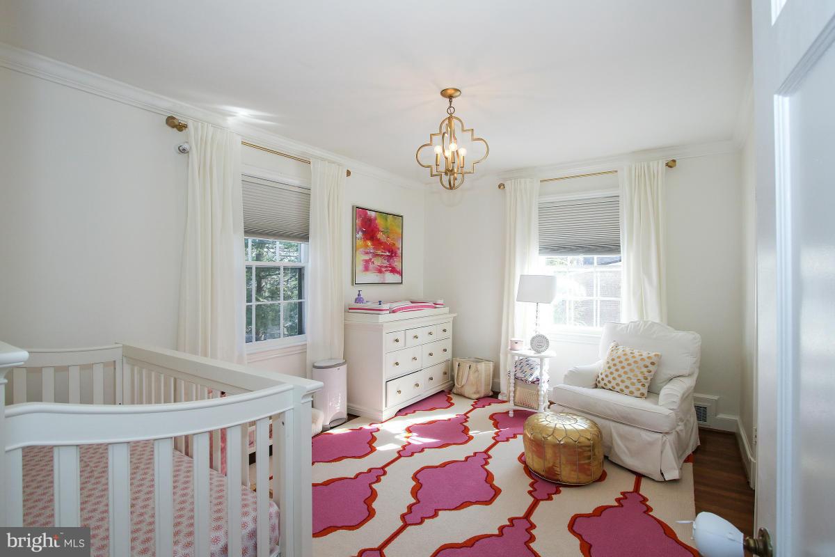 3231 Rittenhouse Street Northwest Washington, DC 20015 - Photo 14 of 27 a bedroom with a bed and a chandelier