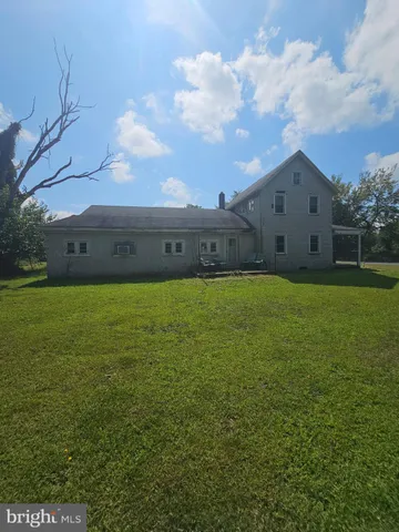 a view of a house with a big yard and a large tree