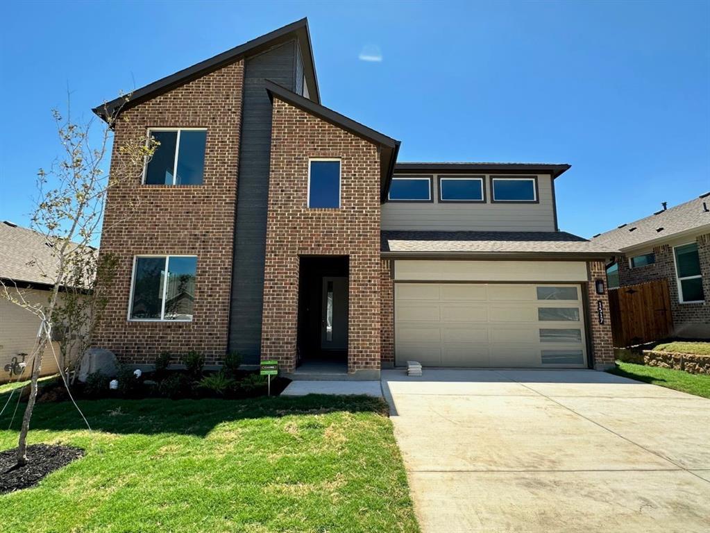 a front view of a house with a yard and garage