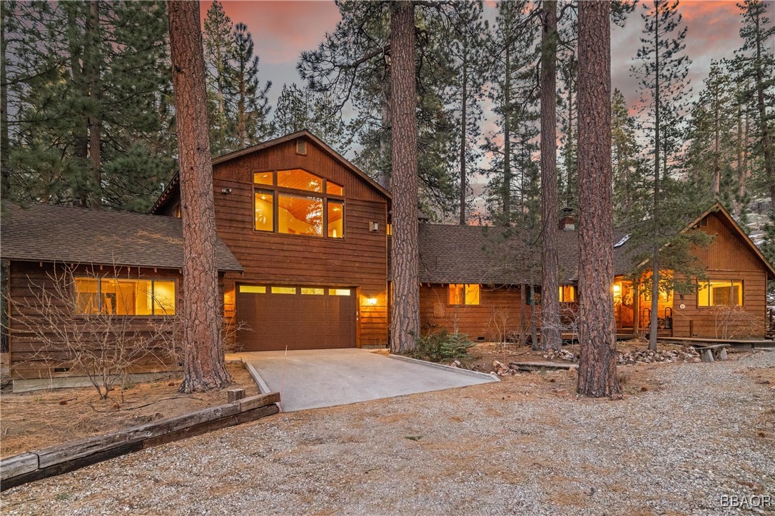 a front view of a house with yard and tree s