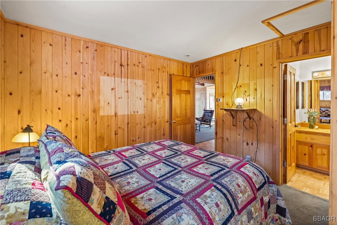 39585 Lakeview Pines Road Big Bear Lake, CA 92315 - Photo 21 of 49 a bedroom with a bed and a chandelier