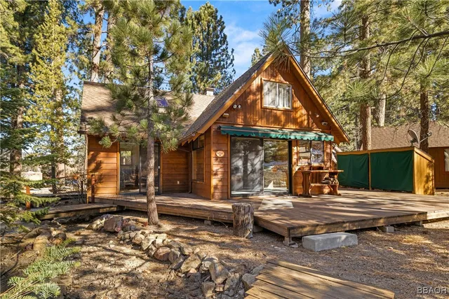 a view of a white house with a large tree in front of it