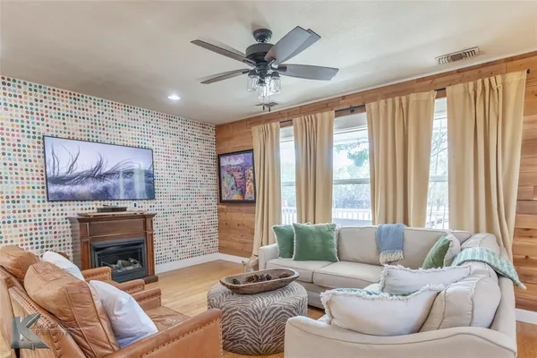 a living room with furniture a fireplace and a large window
