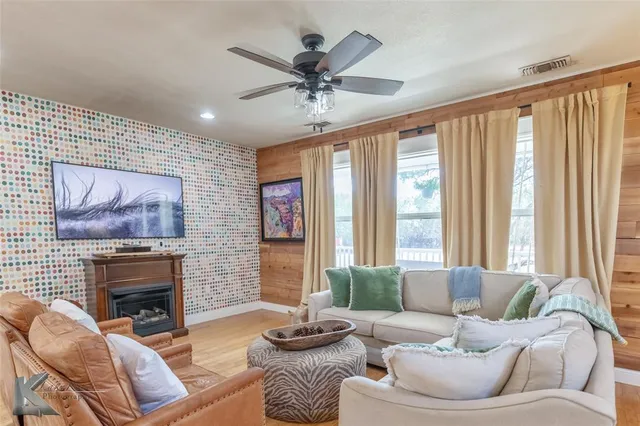 a living room with furniture a fireplace and a large window