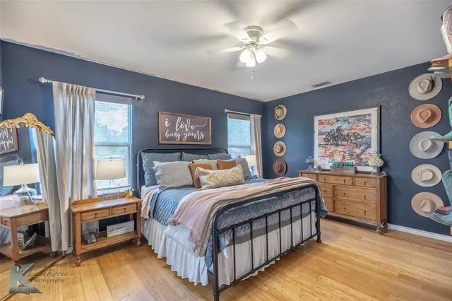 a bedroom with a bed a dresser next to a window