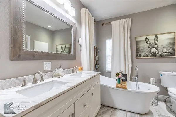 a bathroom with a granite countertop sink mirror and toilet