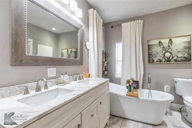 a bathroom with a granite countertop sink mirror and toilet