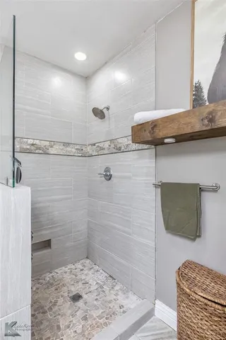 a bathroom with a granite countertop sink a mirror and shower