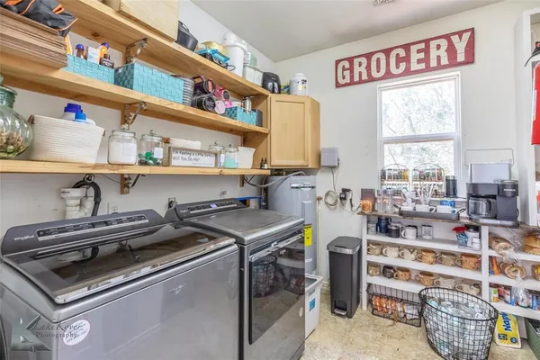 a utility room with stainless steel appliances a stove a sink and a cabinets