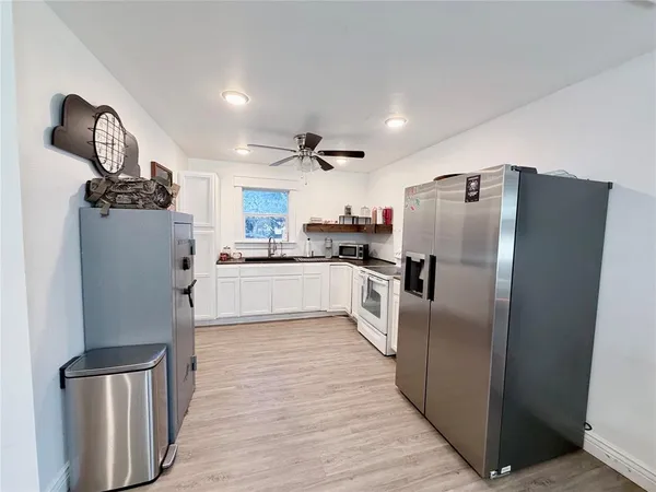 a kitchen with stainless steel appliances granite countertop a refrigerator a stove and a sink