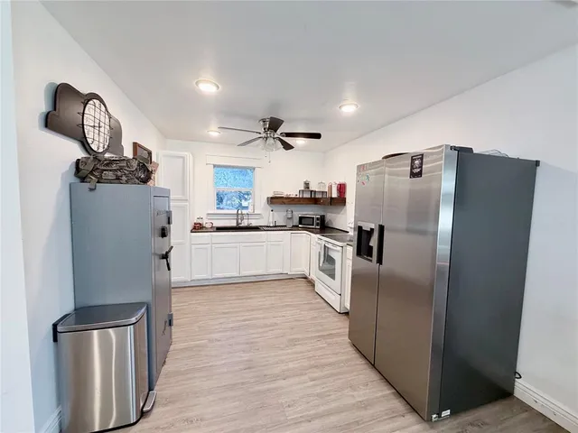 a kitchen with stainless steel appliances granite countertop a refrigerator a stove and a sink