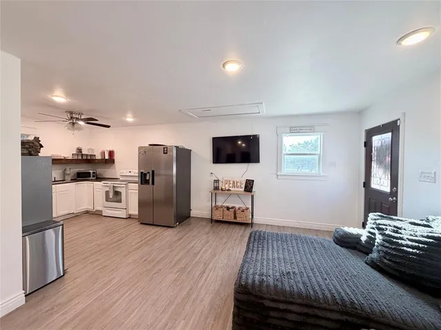 a kitchen with stainless steel appliances wooden floor and a refrigerator
