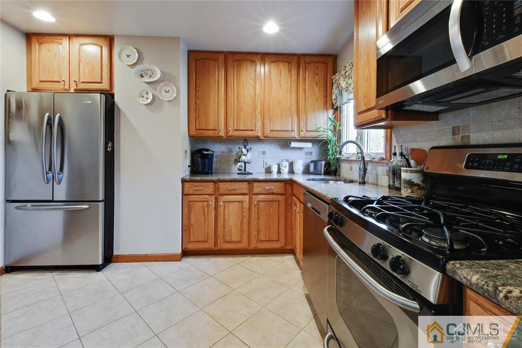 21 Monaghan Road Edison, NJ 08817 - Photo 14 of 25 a kitchen with a stove a refrigerator and a sink
