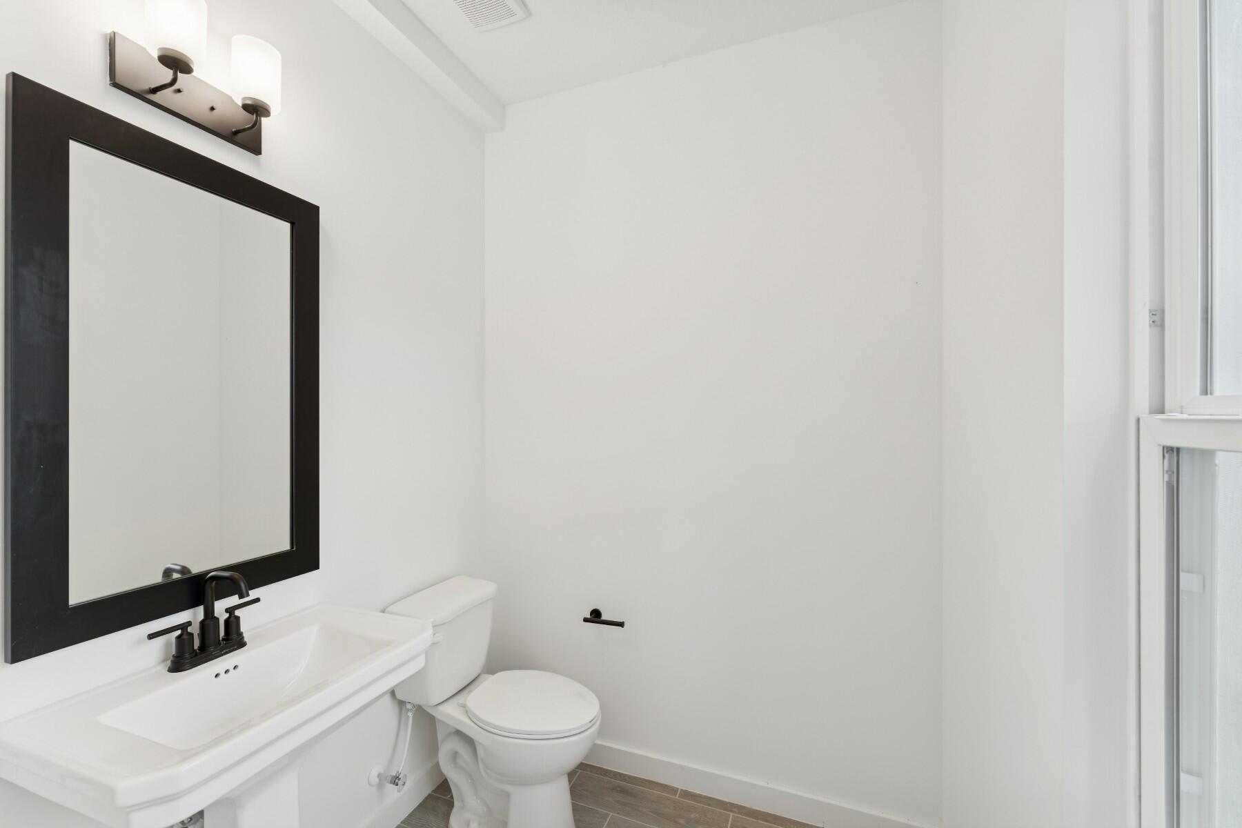 325 Silver Sands Lane, Unit 8 Fort Pierce, FL 34945 - Photo 5 of 47 a bathroom with a toilet a sink and mirror