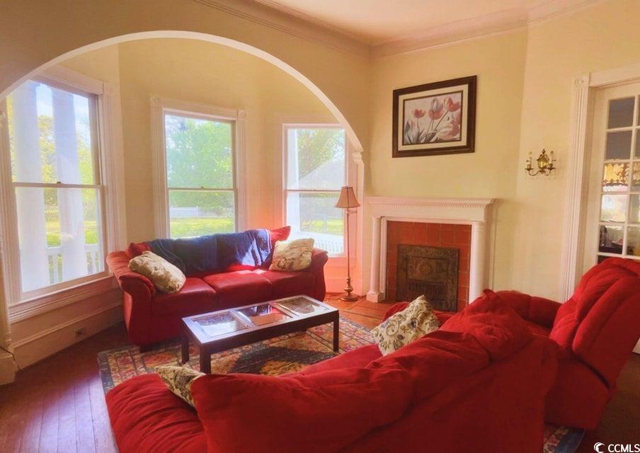 309 North Academy Street Kingstree, SC 29556 - Photo 6 of 38 Living area with crown molding, a fireplace, and hardwood / wood-style floors