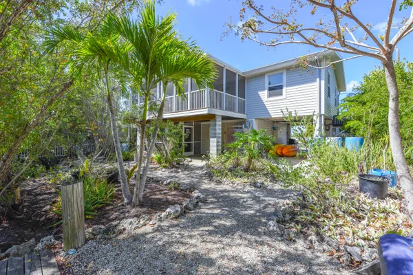 a front view of a house with a yard and potted plants