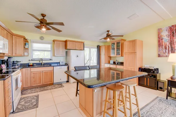 a kitchen with stainless steel appliances kitchen island granite countertop a sink and cabinets