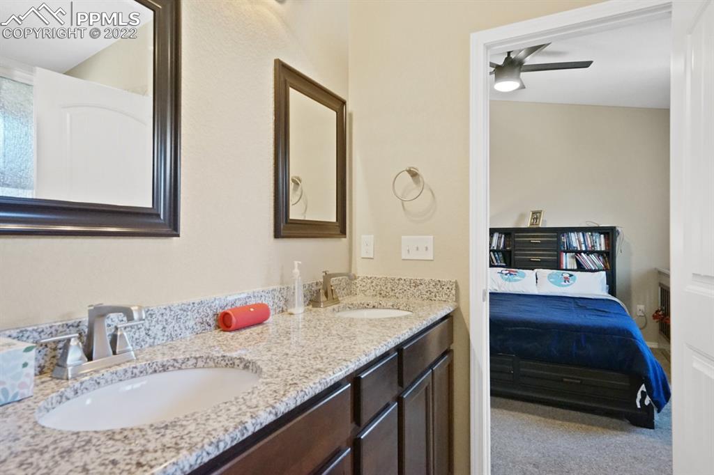 1546 York Road Colorado Springs, CO 80920 - Photo 12 of 23 a en suite bathroom with a granite countertop sink and a mirror