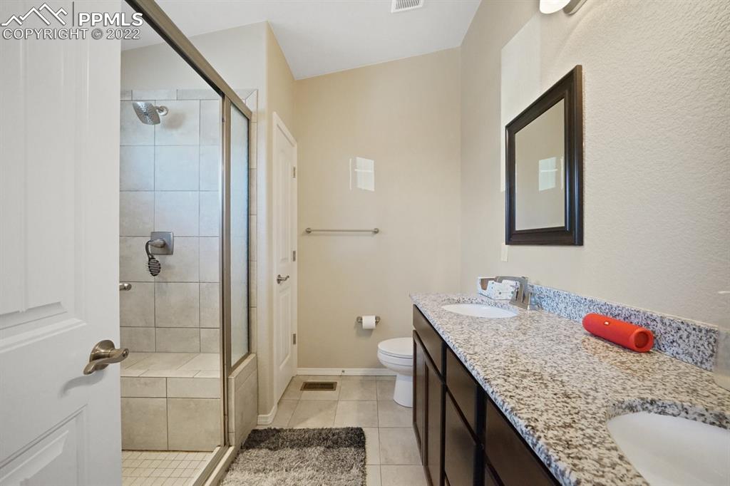 1546 York Road Colorado Springs, CO 80920 - Photo 13 of 23 a bathroom with a granite countertop sink a toilet and shower
