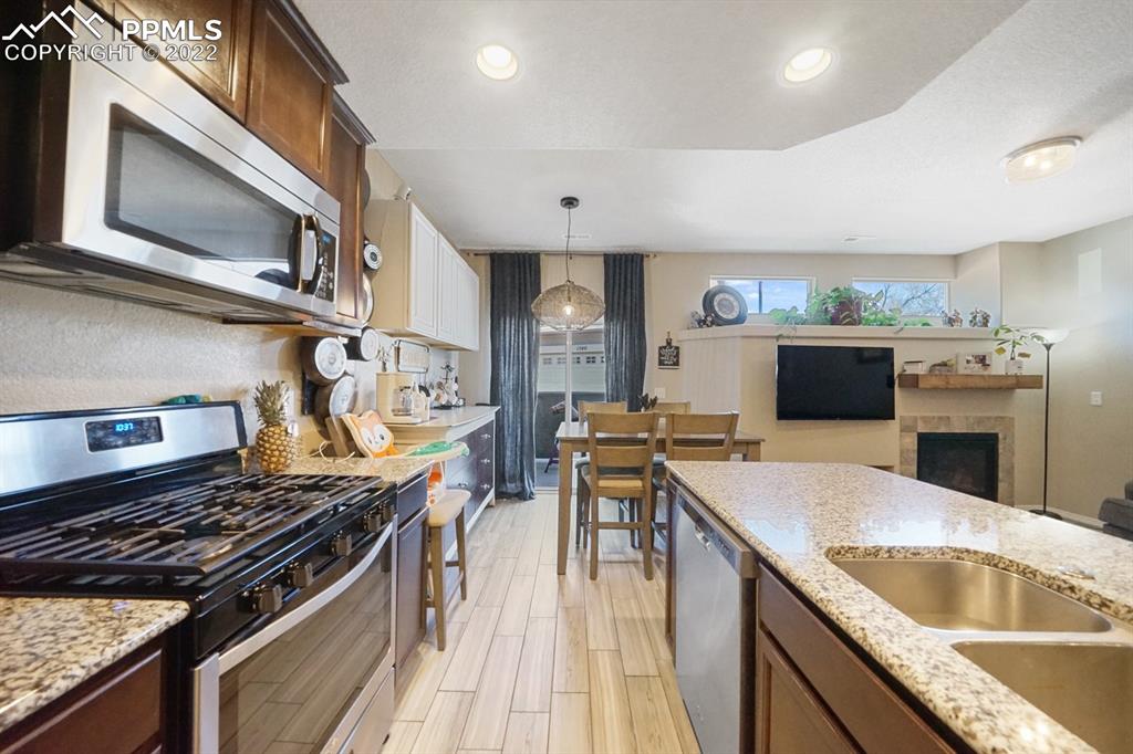 1546 York Road Colorado Springs, CO 80920 - Photo 3 of 23 a kitchen with stainless steel appliances granite countertop a stove top oven a sink dishwasher and a microwave oven with large wooden cabinets