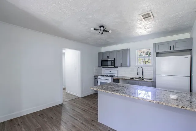 a view of a kitchen with a sink dishwasher a refrigerator and microwave