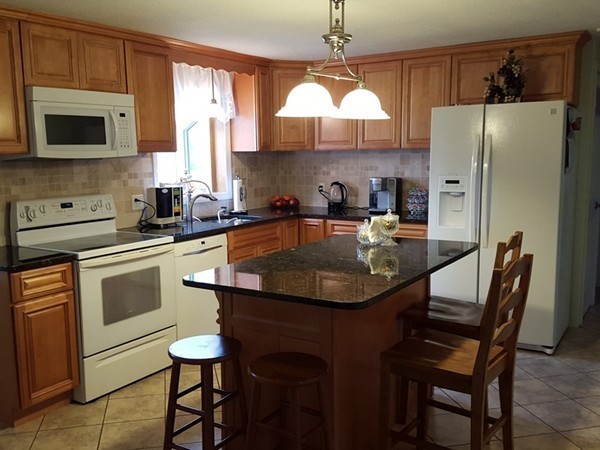 62 Corey Road Springfield, MA 01128 - Photo 7 of 26 a kitchen with stainless steel appliances a table chairs microwave and refrigerator
