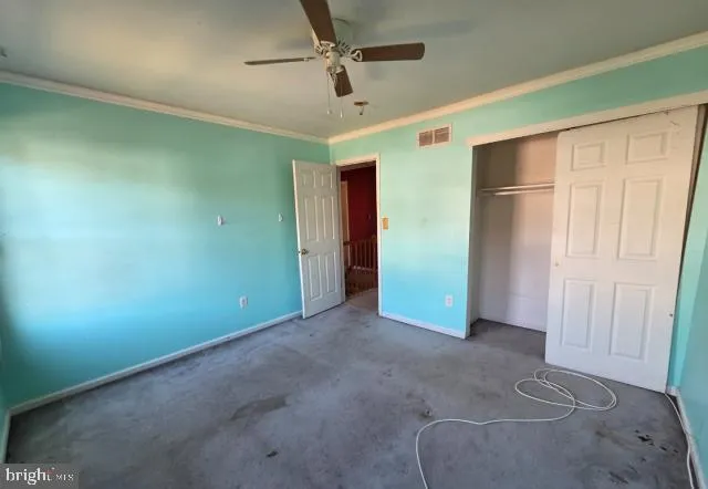 an empty room with closet and windows