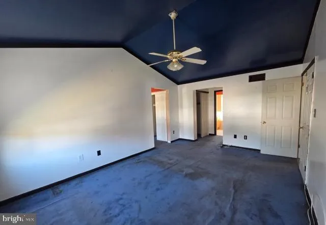 an empty room with a ceiling fan and wooden floor