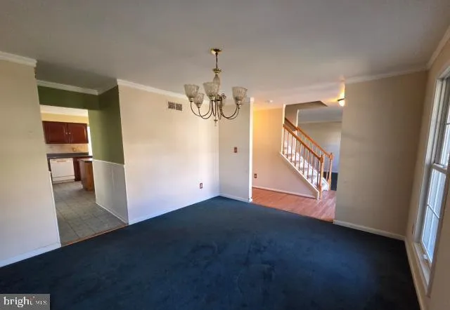 a view of a livingroom with wooden floor and stairs
