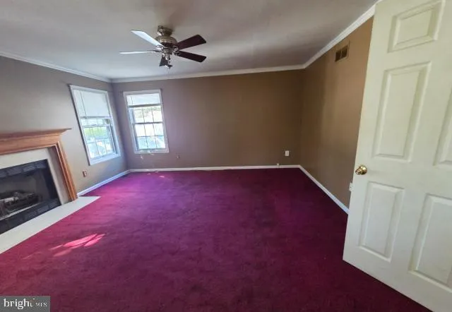 an empty room with windows and fireplace