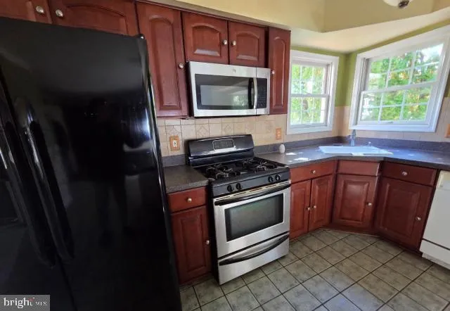 a kitchen with granite countertop a stove microwave and sink