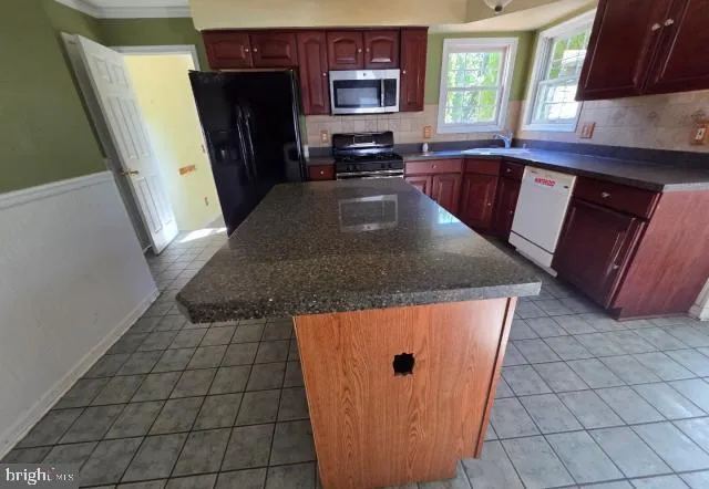 a kitchen with stainless steel appliances granite countertop a refrigerator a sink a stove a microwave a counter and cabinets